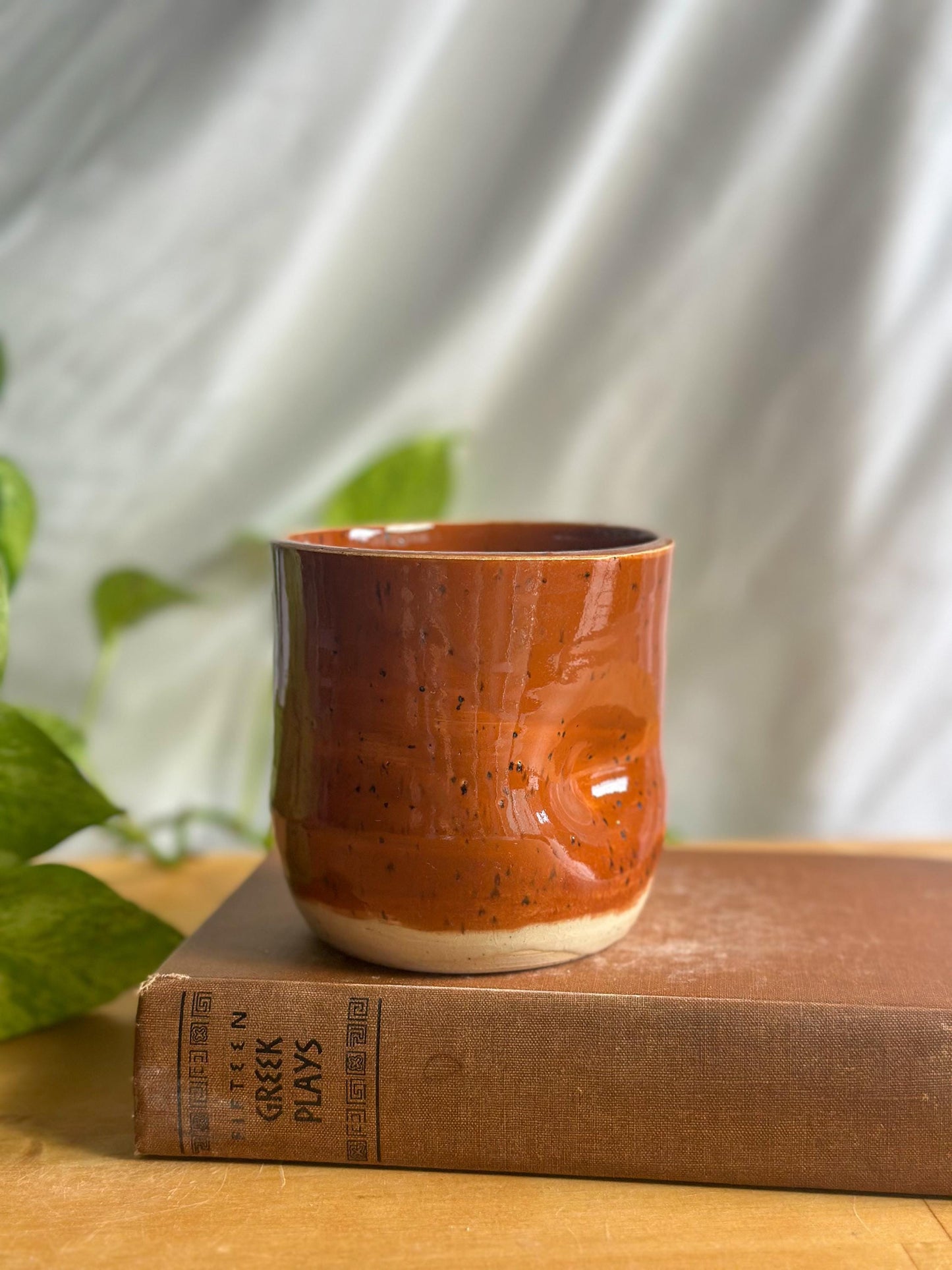 speckled maroon ceramic mug with thumb indent